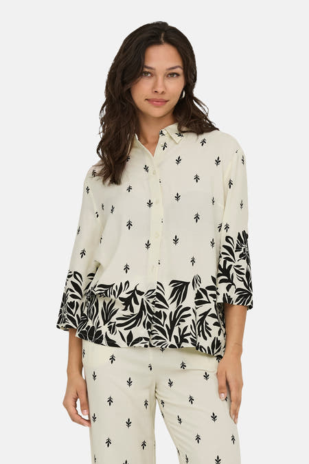 Chemise écru à manches longues de JDY, avec un motif de feuilles et un bord de fleurs noires.