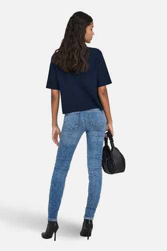 Blauwe gilet van JDY, gezien van achteren, gecombineerd met een jeans en zwarte laarzen.