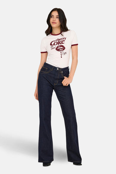 Donkerblauwe flared jeans van ONLY, gedragen met een wit T-shirt met Cherry Coke-print.
