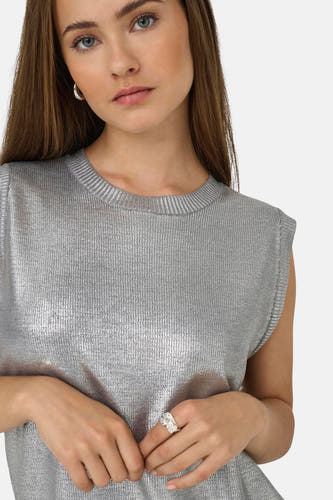 Zilveren mouwloze top van ONLY, met een subtiele glans en gedragen met een zilveren ring en oorbellen.
