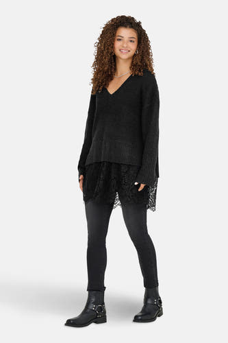 T-shirt V-hals noir d'ONLY, avec détail sur les bords, associé à des jeans foncés et des bottes noires.