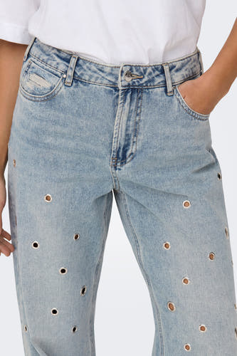 Jean en denim bleu clair large d'ONLY, avec des yeux métalliques dispersés sur les jambes de la jupe, et une chemise blanche.