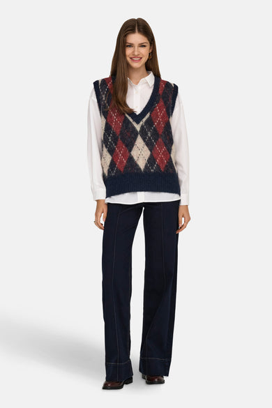Veste bleue sans manches d'ONLY, avec un motif de lunettes, portée sur une chemise blanche et un pantalon foncé.