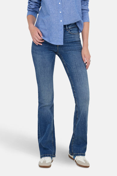 Blauw uitlopende jeans van JDY, gedragen met een gestreept overhemd en sneakers.
