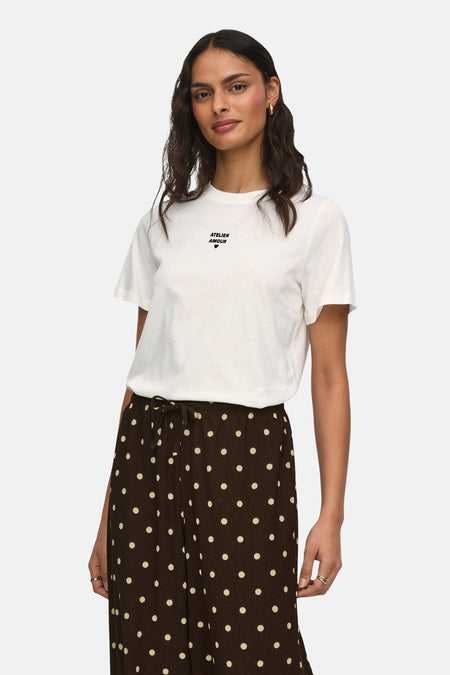 T-shirt blanc à manches courtes de JDY, porté avec un pantalon marron à pois blancs, vu de dos.