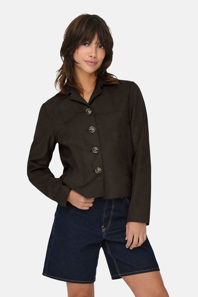 Bruine korte jas van JDY, met lange mouwen en knoopsluiting, gecombineerd met een donkerblauwe denim broek.

