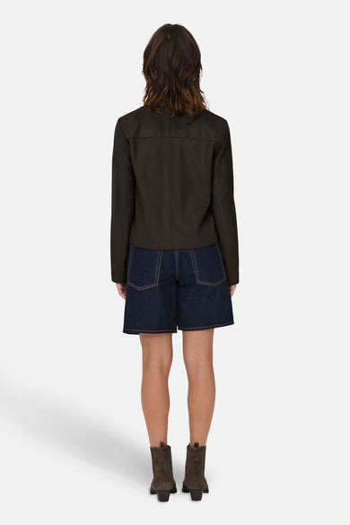 Bruine korte jas van JDY, met een effen patroon, gedragen met denim shorts en bruine laarzen.
