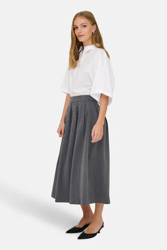 Robe grise de JDY, associée à une chemise blanche et des chaussures noires, représentée en position debout.