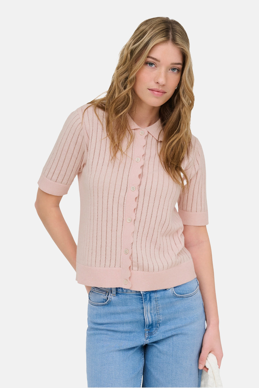 Gilet rose de ONLY, à manches courtes, fermeture boutonnée et porté avec un jean.