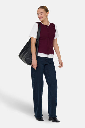 Veste Bordeaux de JDY, portée sur un t-shirt blanc avec des jeans noirs et une sac noir.