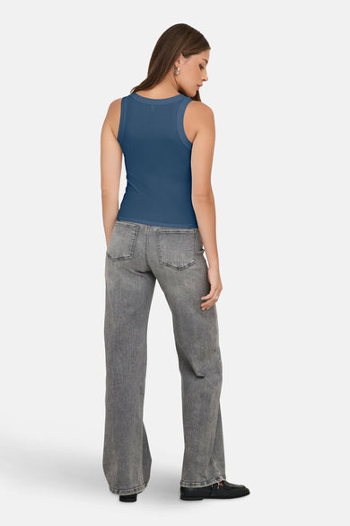 T-shirt bleu ONLY®, avec un col rond et porté avec des jeans gris et des chaussures noires.