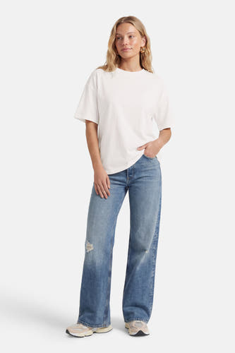 Wit T-shirt met korte mouwen van JDY, gecombineerd met blauwe jeans en lichte sneakers.