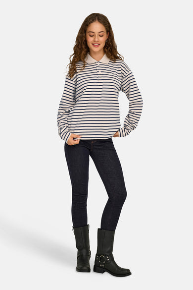 Polo écru à manches longues de JDY, avec des rayures bleues, associé à un jeans foncé et des bottes noires.