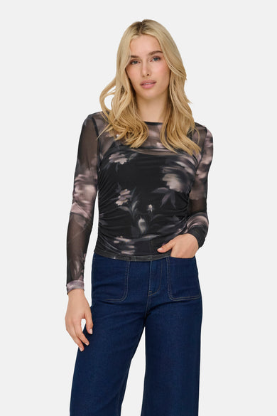 Multicolor T-shirt met lange mouwen van ONLY, met bloemenpatroon, gecombineerd met donkerblauwe jeans.
