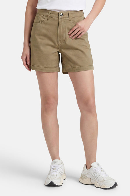 Beige korte broek van ONLY® met gerolde pijpen, klassieke vorm, voorzien van zakken en knoopsluiting, gedragen met witte sneakers.