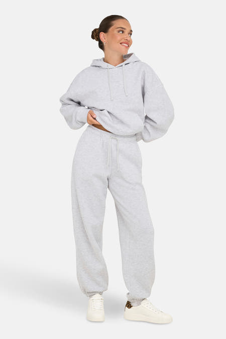 Grijze joggingbroek van ONLY, met bijpassende hoodie en witte sneakers.
