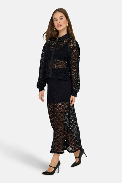 Robe longue noire ONLY, avec des détails bordés et combinée à une blouse bordée et des escarpins noirs.