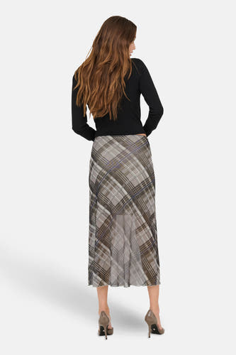 Longue jupe multicolore d'ONLY, avec un motif à carreaux et associée à une chemise noire et des talons hauts.