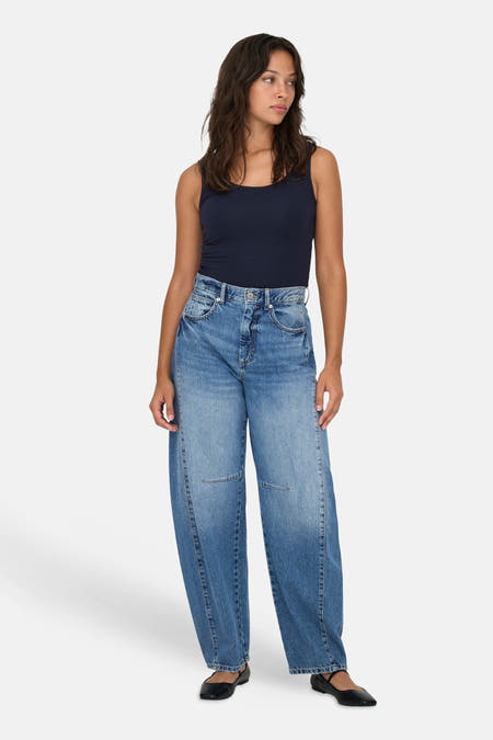 Jean denim bleu marine avec une forme spéciale d'ONLY, associé à un haut bleu foncé et des chaussures noires.