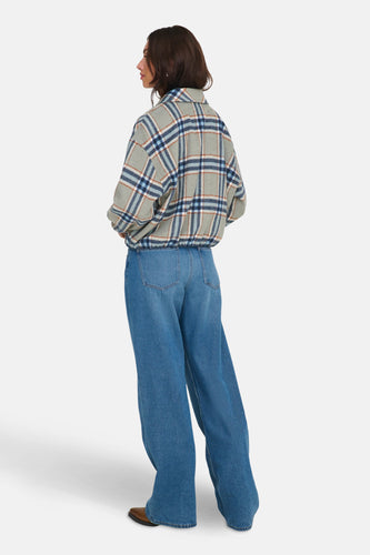 Manteau court multicolore d'ONLY, avec un motif à carreaux et porté avec des jeans larges et des chaussures marron.