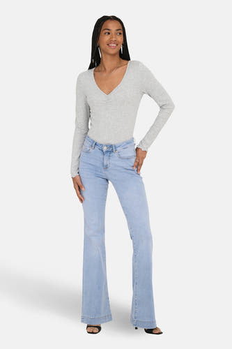 Lichtblauwe flared jeans van ONLY, met een grijze top en zwarte sandalen.
