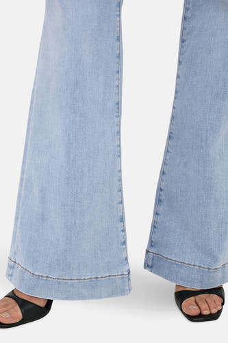 Lichtblauwe flared jeans van ONLY, met zoomdetails en gecombineerd met zwarte sandalen.