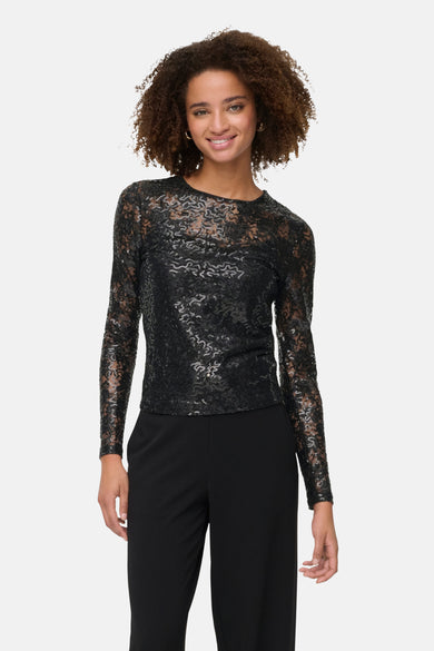 Zwarte blouse met lange mouwen van ONLY, met een subtiel patroon en gedragen met een zwarte pantalon.
