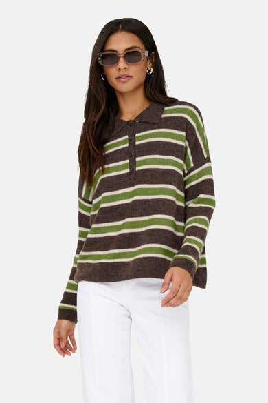 Gilet multicolore ONLY, avec des manches longues et un motif rayé, porté avec un pantalon blanc et des chaussures marron.