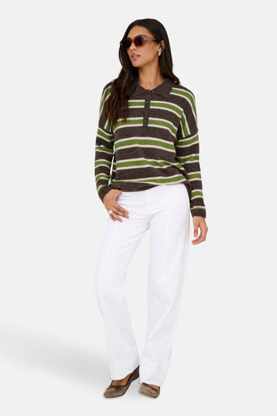 Multicolor trui van ONLY, met lange mouwen en een gestreept patroon, gedragen met een witte broek en bruine schoenen.
