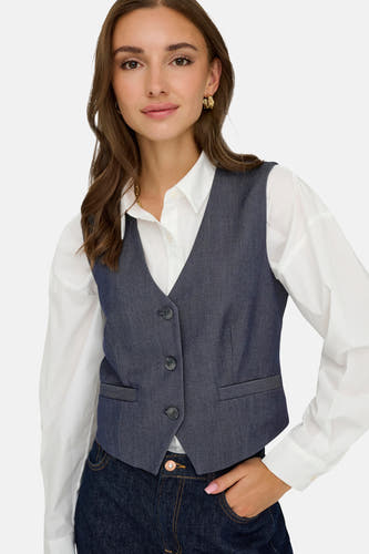 Donkerblauw denim blazer van JDY, gecombineerd met een wit overhemd en een donkerblauwe jeans.
