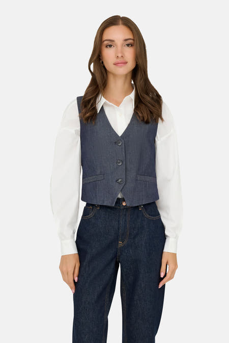 Donkerblauw denim blazer van JDY, gedragen over een wit overhemd en donkerblauwe jeans.