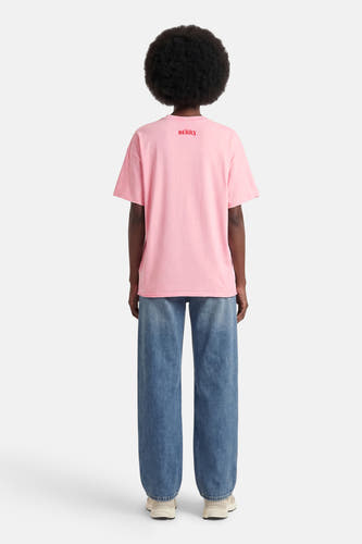 T-shirt à manches courtes rose d'ONLY, avec le texte rouge "Sweet Berry" dans le dos, porté avec un jean ample.
