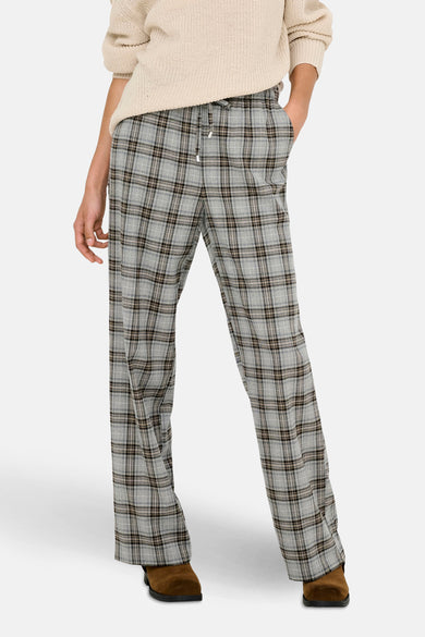Pantalon gris ONLY® avec motif à carreaux, associé à une chemise tricotée et des chaussures brunes.