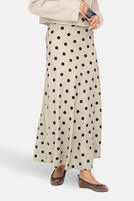 Lange ecru rok van JDY, met een zwart stippenpatroon en zichtbare bruine ballerina's.
