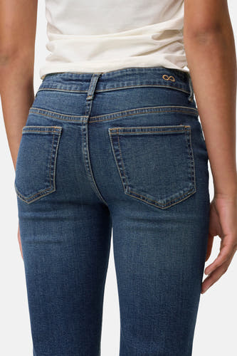 Donkerblauwe flared jeans van JDY, met achterzakken en riemlussen, gezien van achteren.
