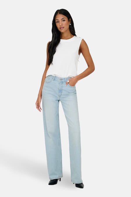 Lichtblauwe, wijde jeans van ONLY, met een casual top en zwarte hakken.
