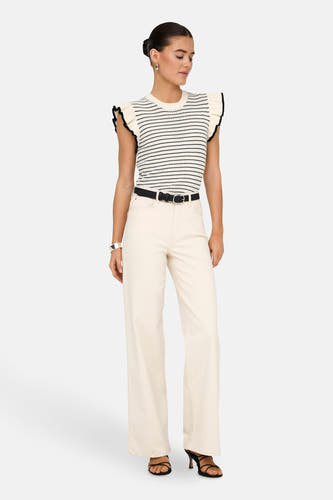 Witte pull van JDY, met zwarte strepen en gerimpelde mouwen, gedragen met een zwarte riem en off-white broek.