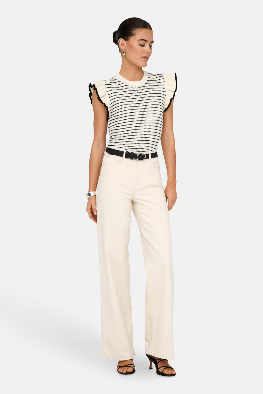 Witte pull van JDY, met zwarte strepen en gerimpelde mouwen, gedragen met een zwarte riem en off-white broek.