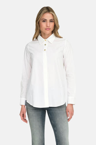 Chemise blanche à manches longues de ONLY, portée avec des jeans bleu-gris et des bottes noires.