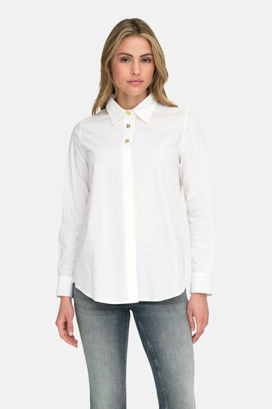 Chemise blanche à manches longues de ONLY, portée avec des jeans bleu-gris et des bottes noires.