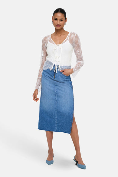 Blouse blanche à longues manches de ONLY, portée avec une jupe en jeans fendue.