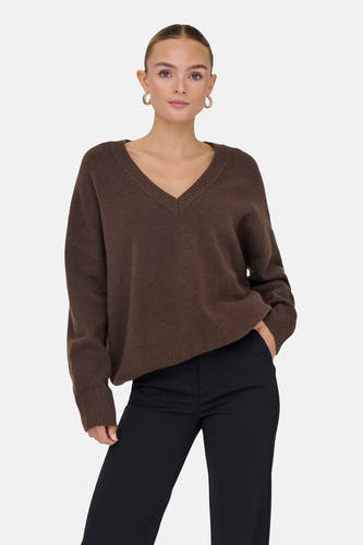 Bruine trui met V-hals van ONLY, gedragen met zwarte pantalon en gouden oorbellen.
