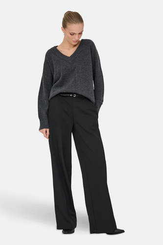 Grijze trui met V-hals van ONLY®, gecombineerd met een zwarte broek en een riem.
