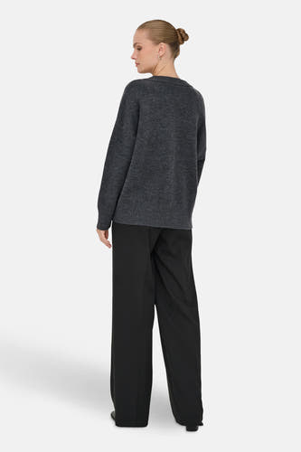Pull à col V gris ONLY, avec des manches longues et associé à un pantalon noir.