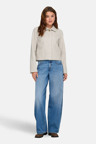 Ecru korte jas van ONLY, gedragen met wijde jeans en bruine laarzen.