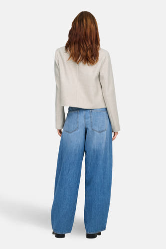 Ecru manteau court de ONLY, avec des manches longues et en combinaison avec des jeans larges.
