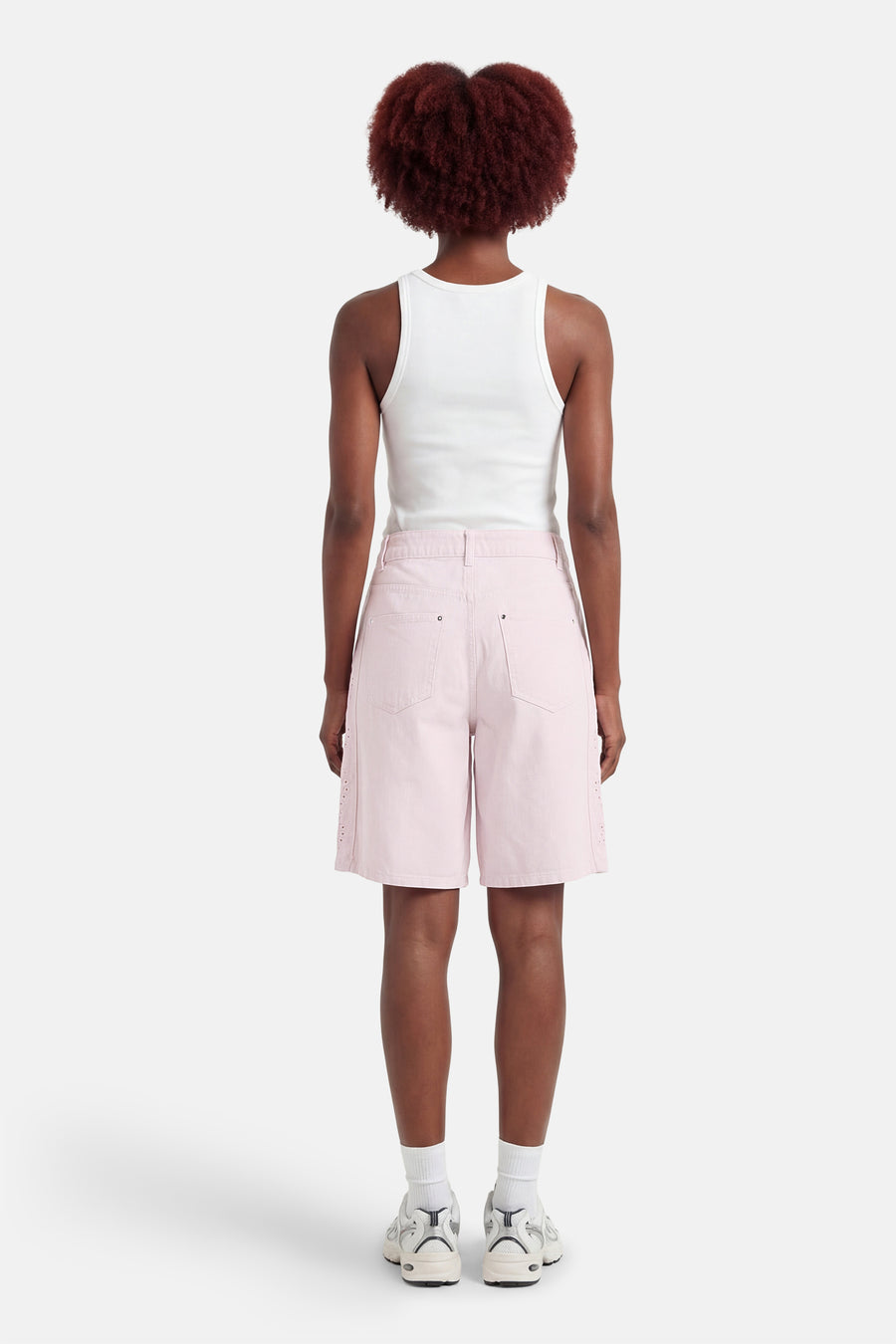 Short rose de ONLY, avec des détails de bordures en dentelle, combiné avec une chemise blanche et des baskets.