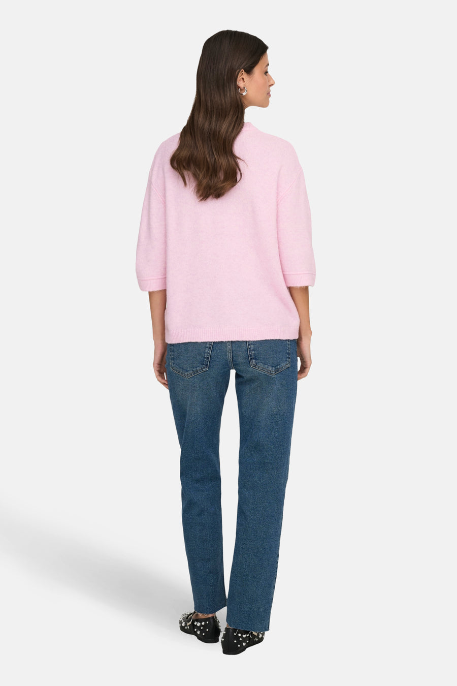 Roze trui met ronde hals van JDY, gezien van achteren, gecombineerd met een blauwe jeans en versierde schoenen.
