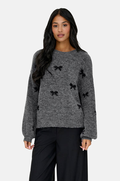 Sweat-shirt gris à col rond de ONLY, orné de rayures noires et associé à un pantalon noir et des bottes.