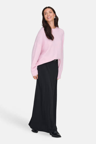 Roze trui met ronde hals van JDY, gedragen met een lange zwarte rok en zwarte laarzen.